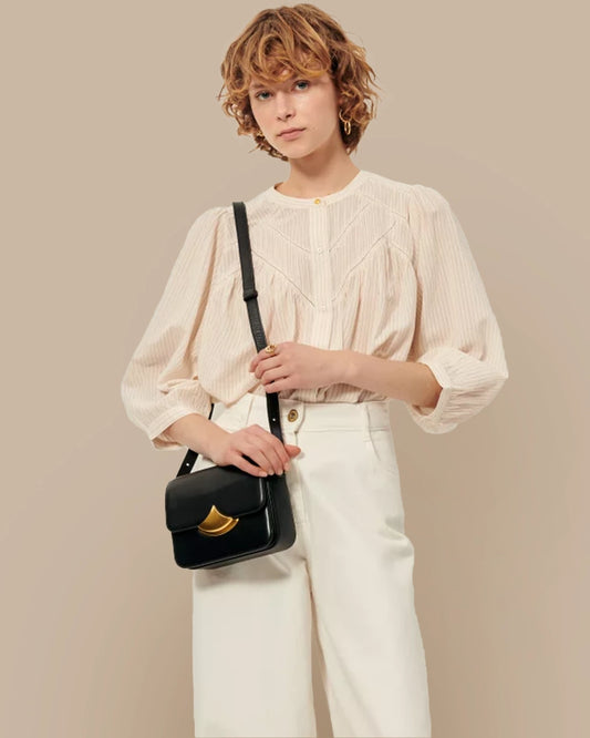 Blusa de Sessun con cuello redondo, de color crudo con una rayita fina y detalles de vainicas en la pechera.